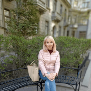 blonde polnische Frau sitz auf einer Bank in einem Park