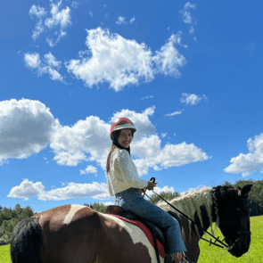 Polnische Frau reitet auf einem Pferd und lächelt